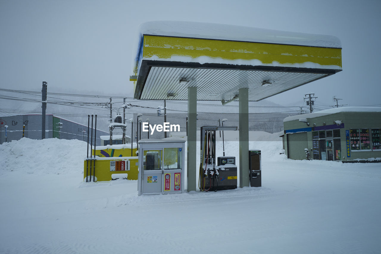 snow, cold temperature, winter, gas station, nature, architecture, no people, sky, built structure, power generation, building exterior, fuel pump, outdoors, day, environment, transportation