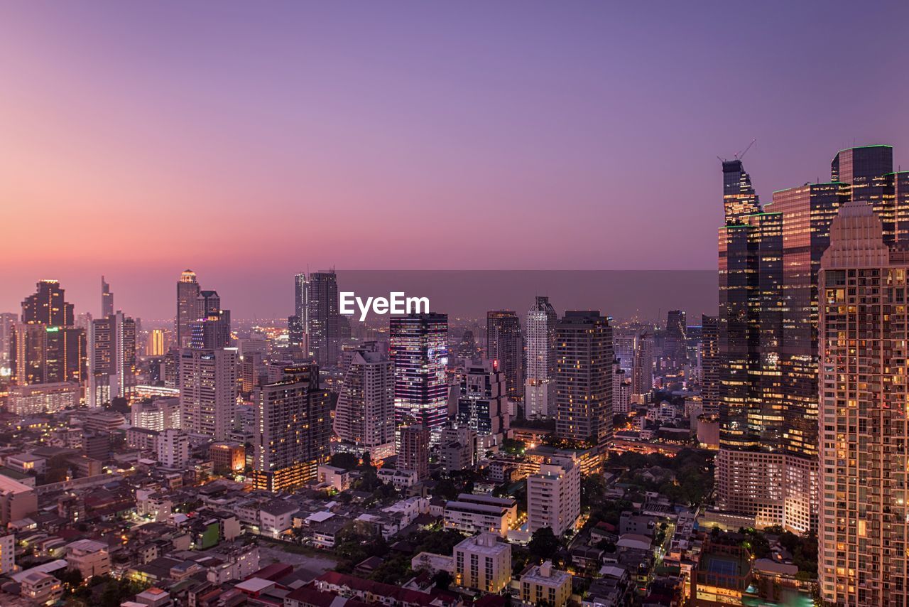 Aerial view of city lit up during sunset