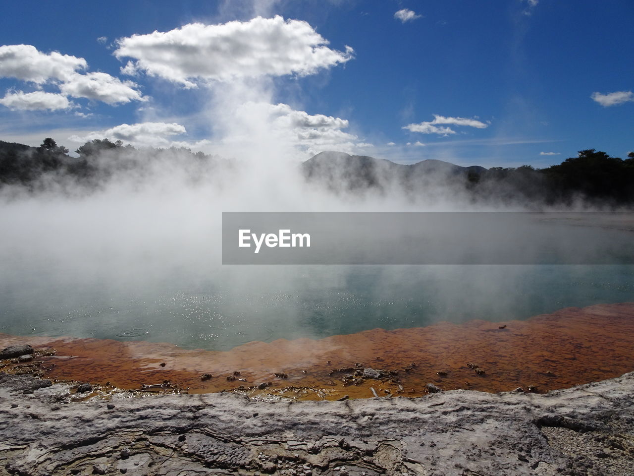 Smoke emitting from geyser against sky