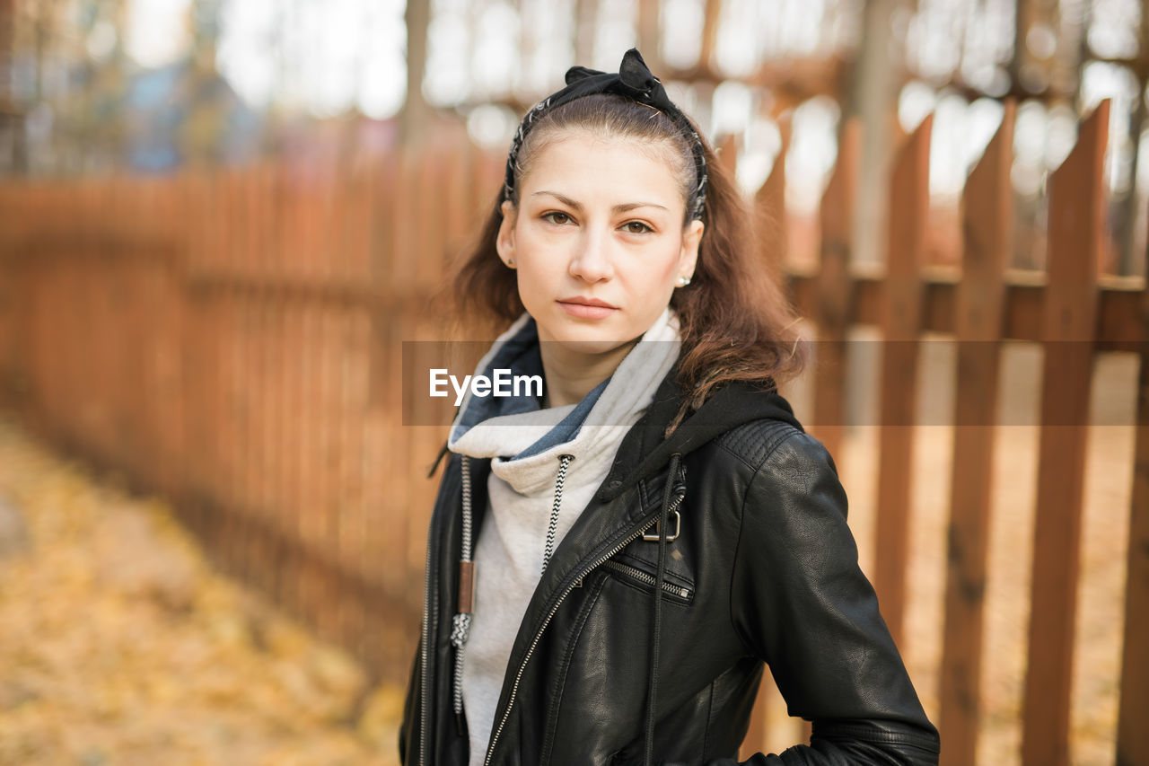 portrait of smiling young woman standing in park