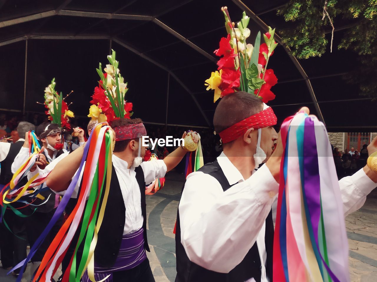 LOW ANGLE VIEW OF PEOPLE IN MULTI COLORED TRADITIONAL CLOTHING