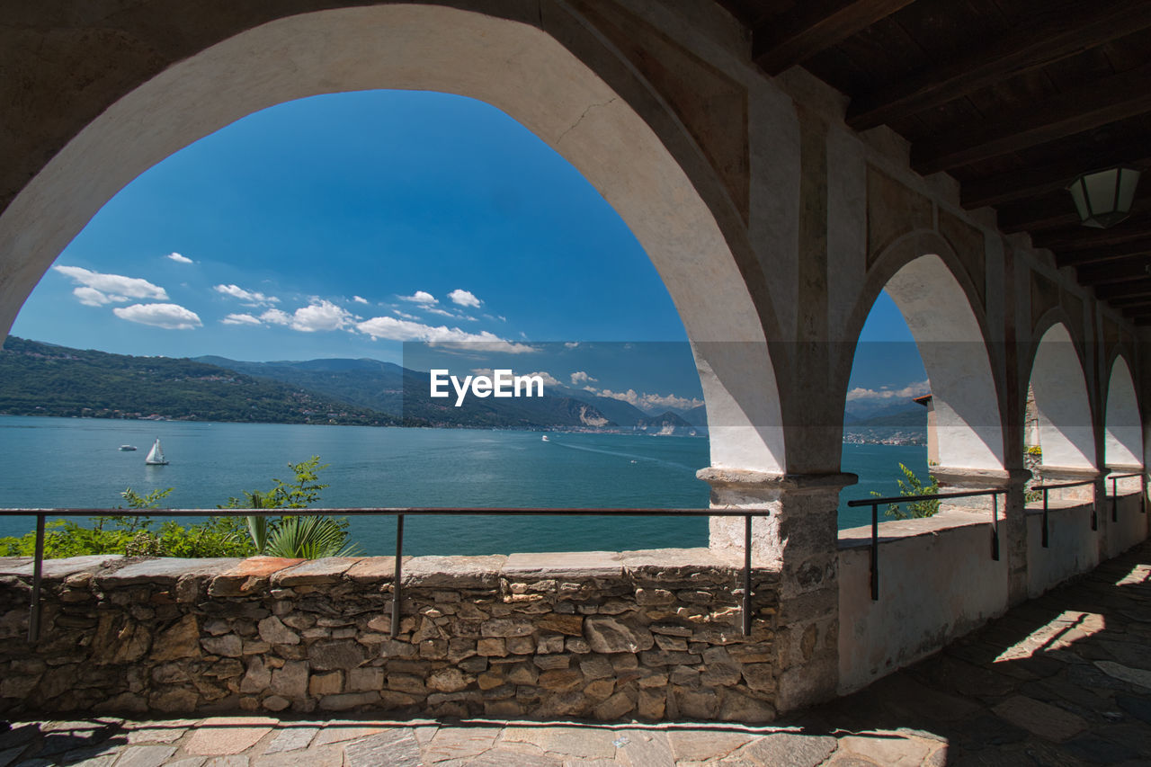 Built structure by lake against sky