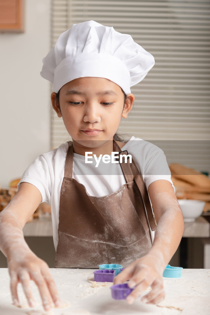 Close-up of girl preparing food at kitchen