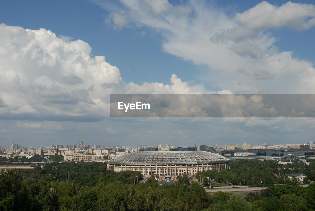 Buildings in city against cloudy sky