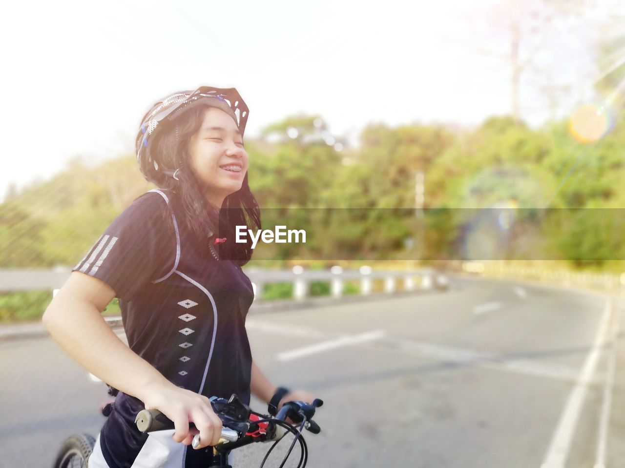 Smiling teenage girl cycling on road