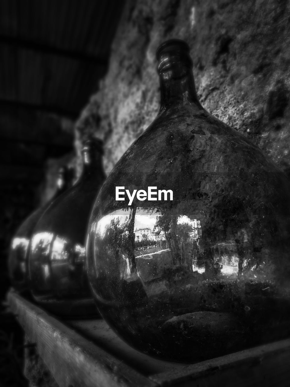 Close-up of old glass bottle against wall