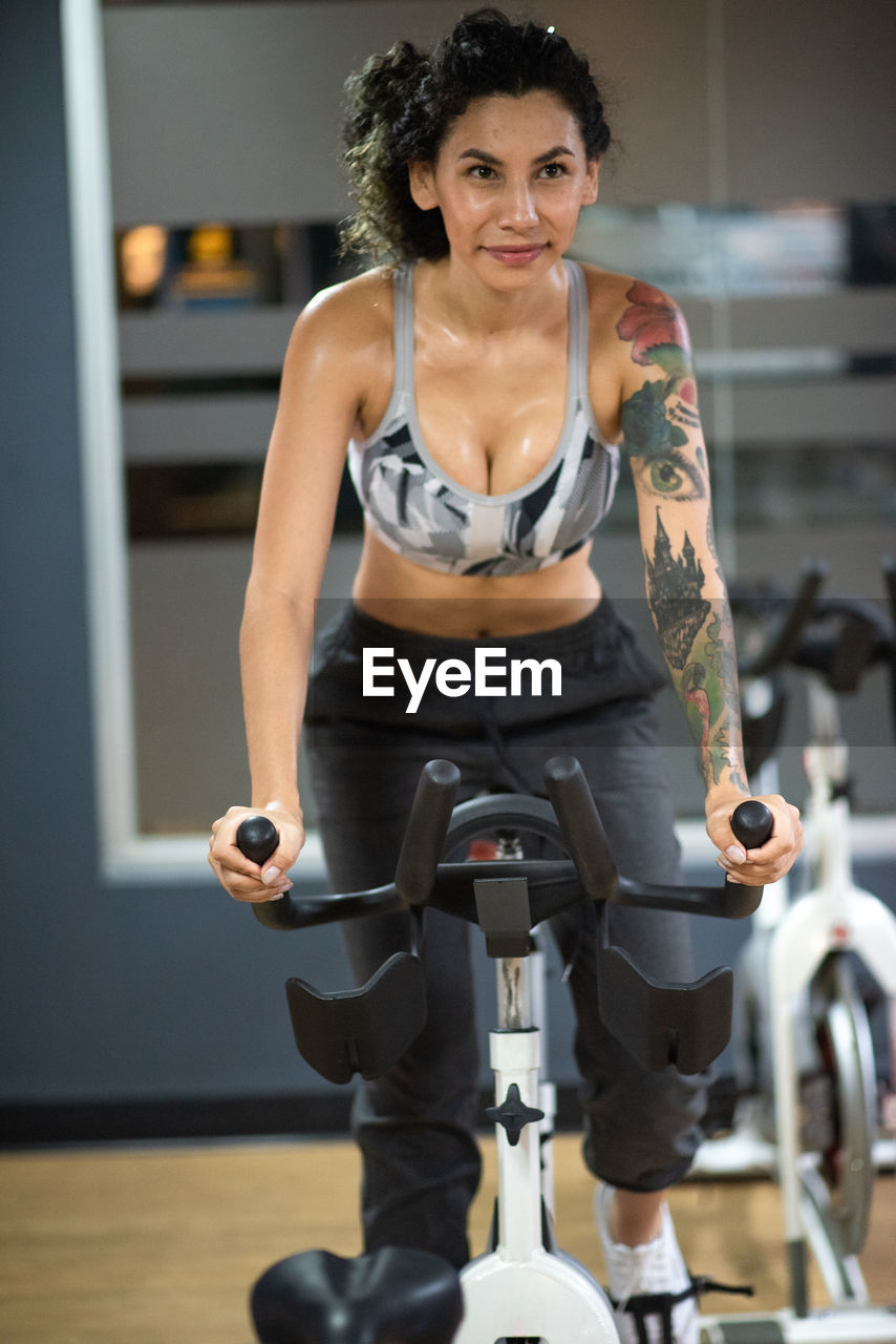 Young woman spinning at the gym