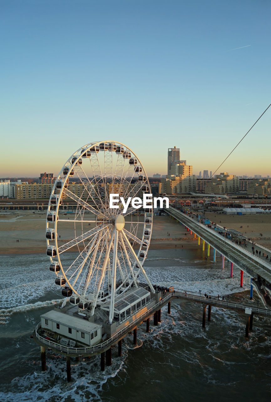 FERRIS WHEEL AND BUILDINGS AGAINST CLEAR SKY