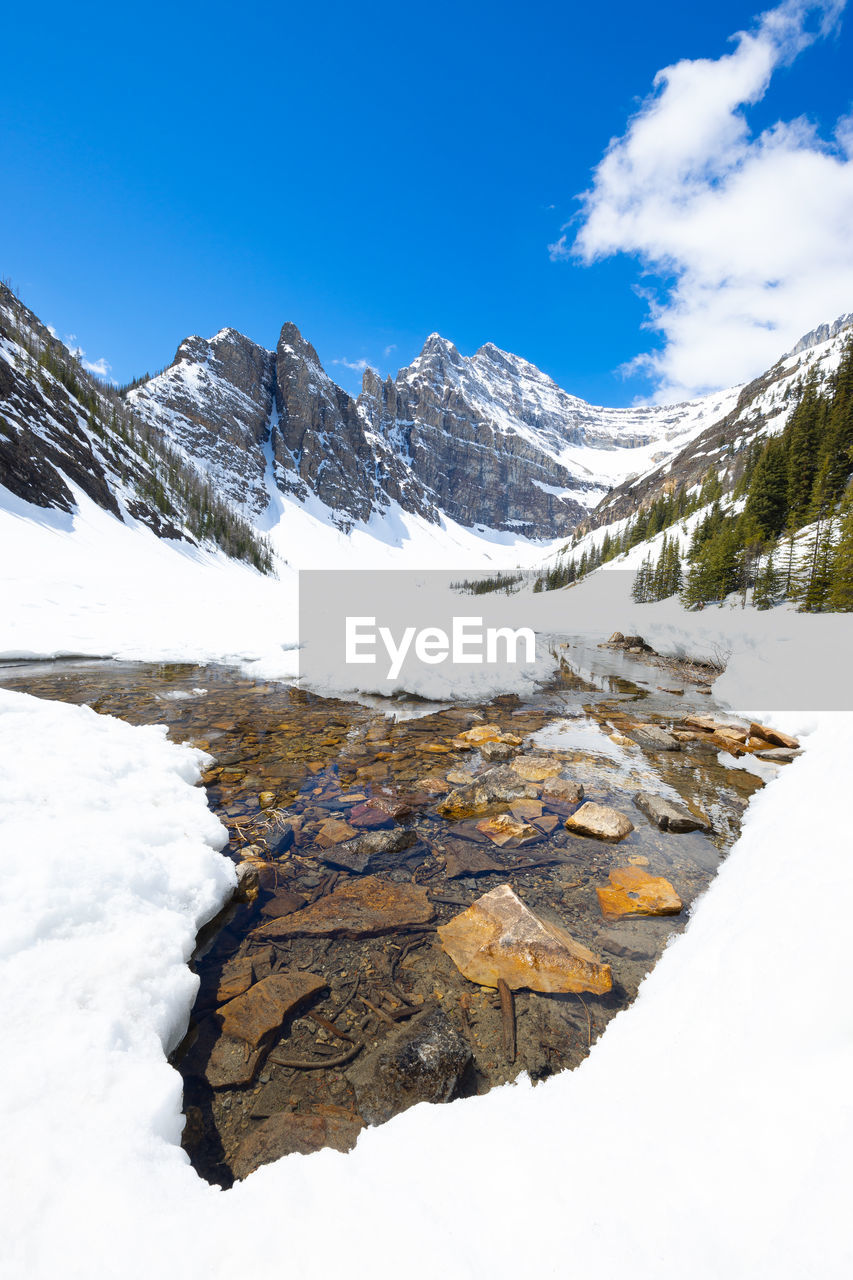 A break in the icea allows for a view of the crystal clear water of lake agnes.