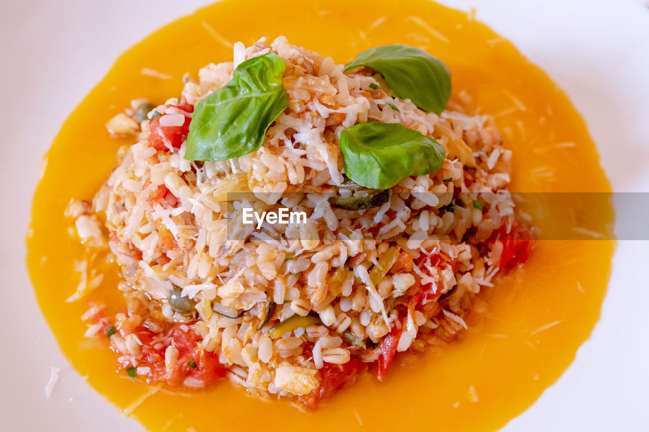 Ready-made plate of whole grains, with cherry tomatoes, courgettes and capers.