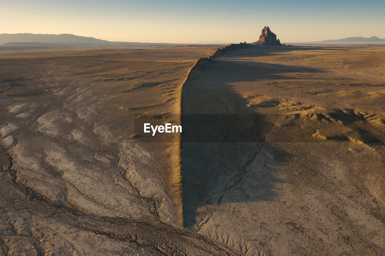 Scenic view of shiprock against sky during sunset