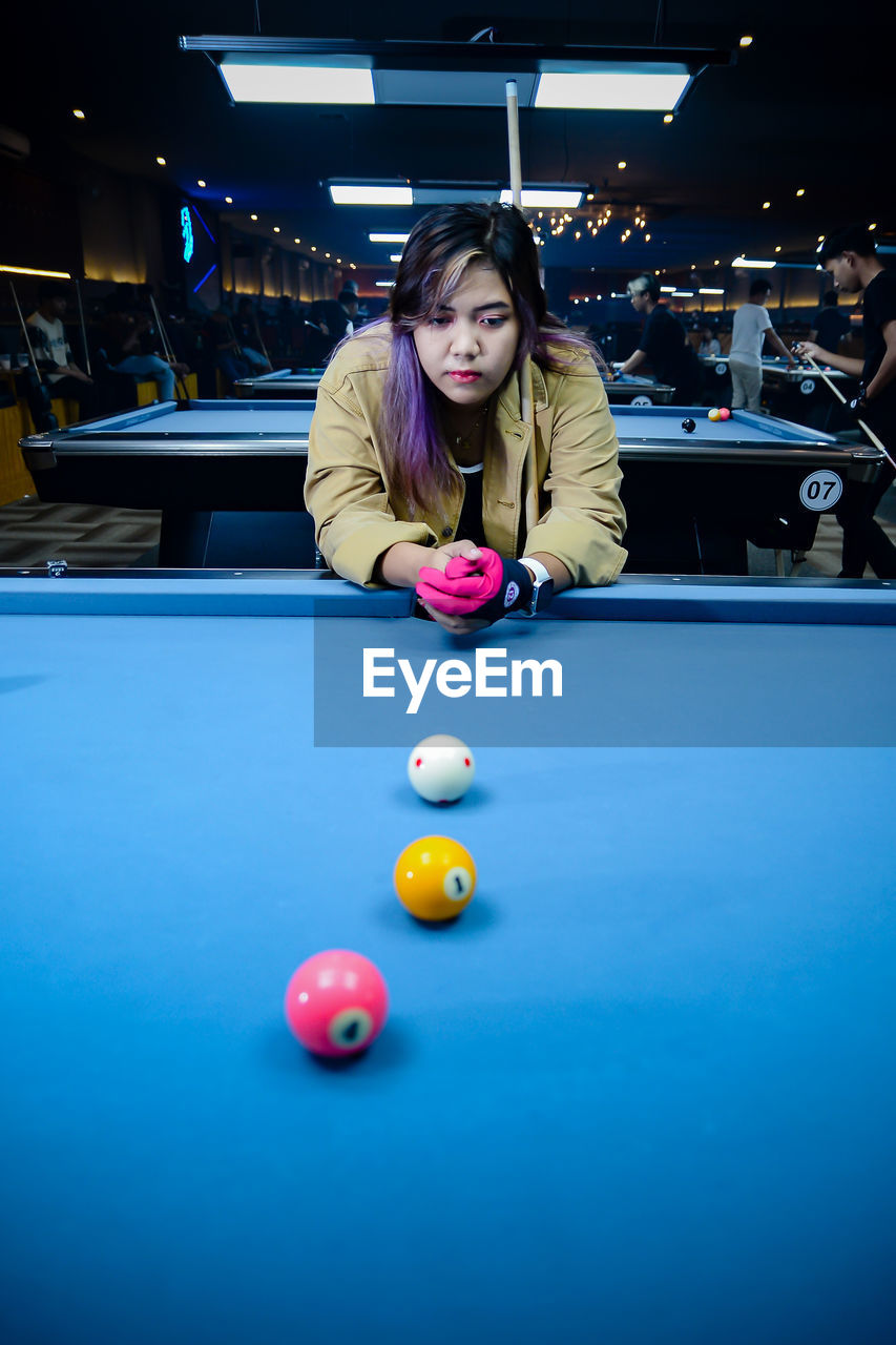 portrait of woman playing pool at home