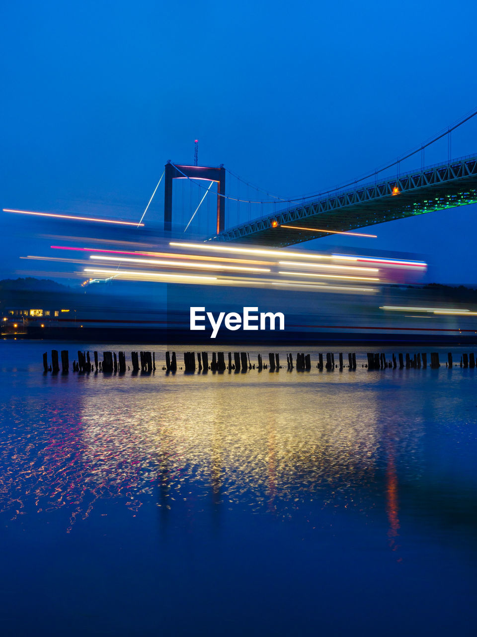 Ferry passing bridge in evening light
