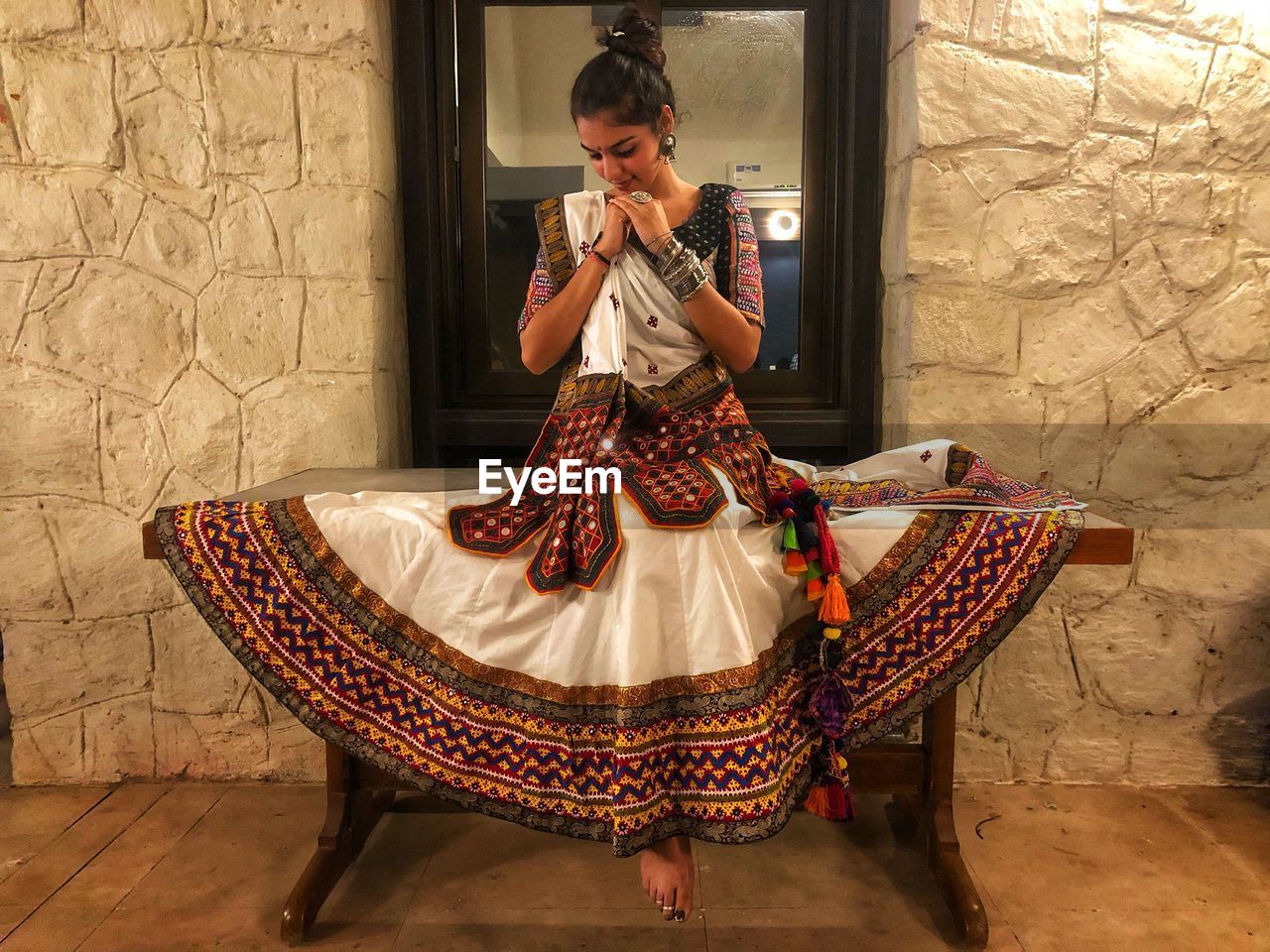 Woman in traditional clothing sitting on table