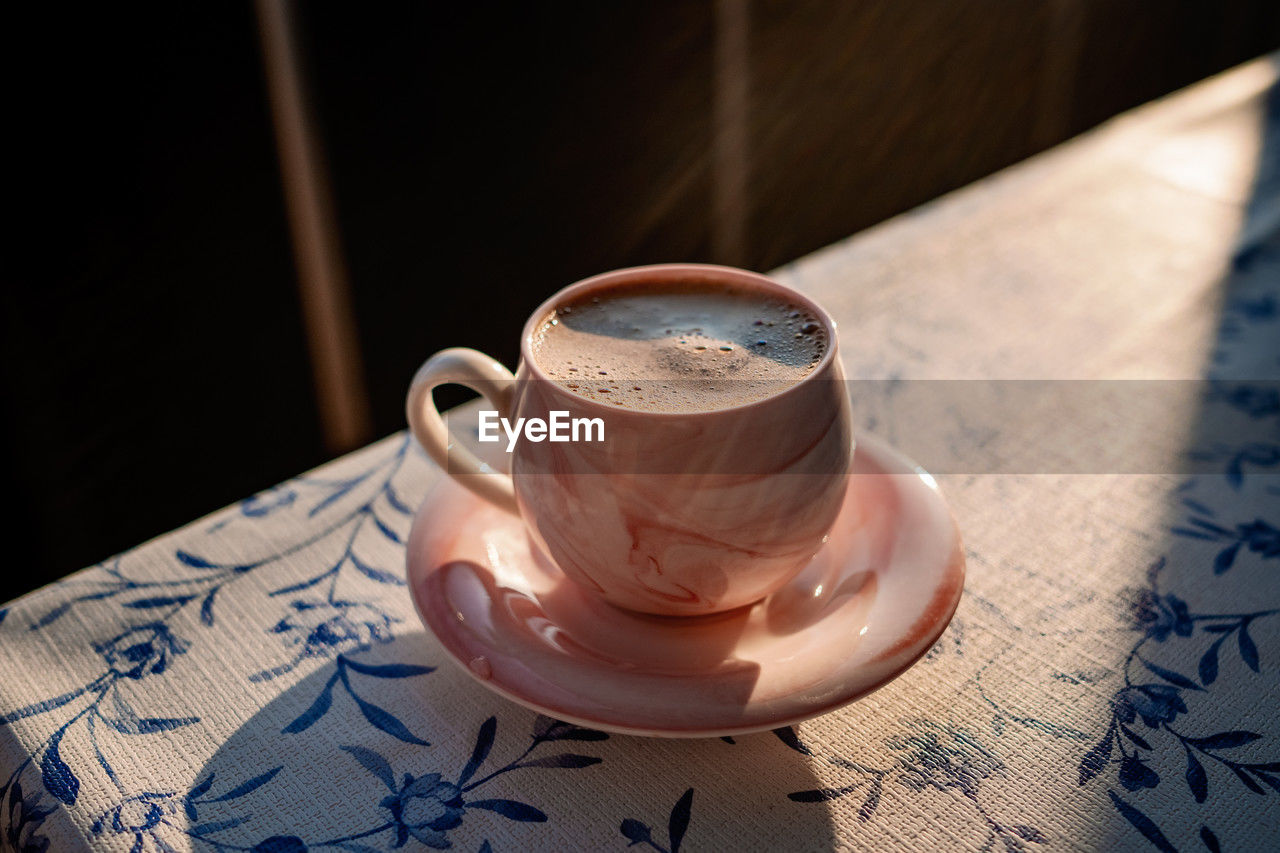 Turkish coffee in a pink cup with a saucer in the sun close-up. coffee break. high quality photo