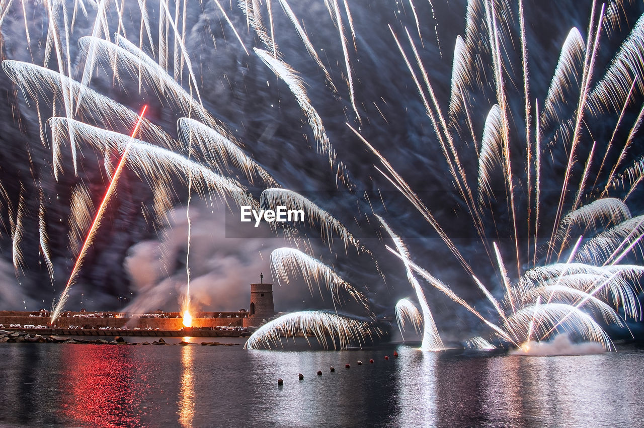 Firework display over river at night