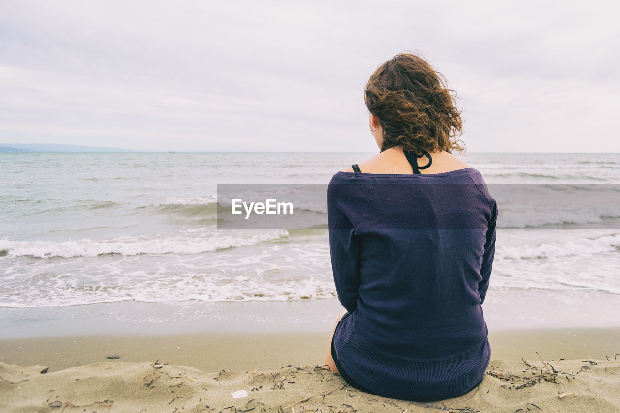 Rear view of woman looking at sea against sky