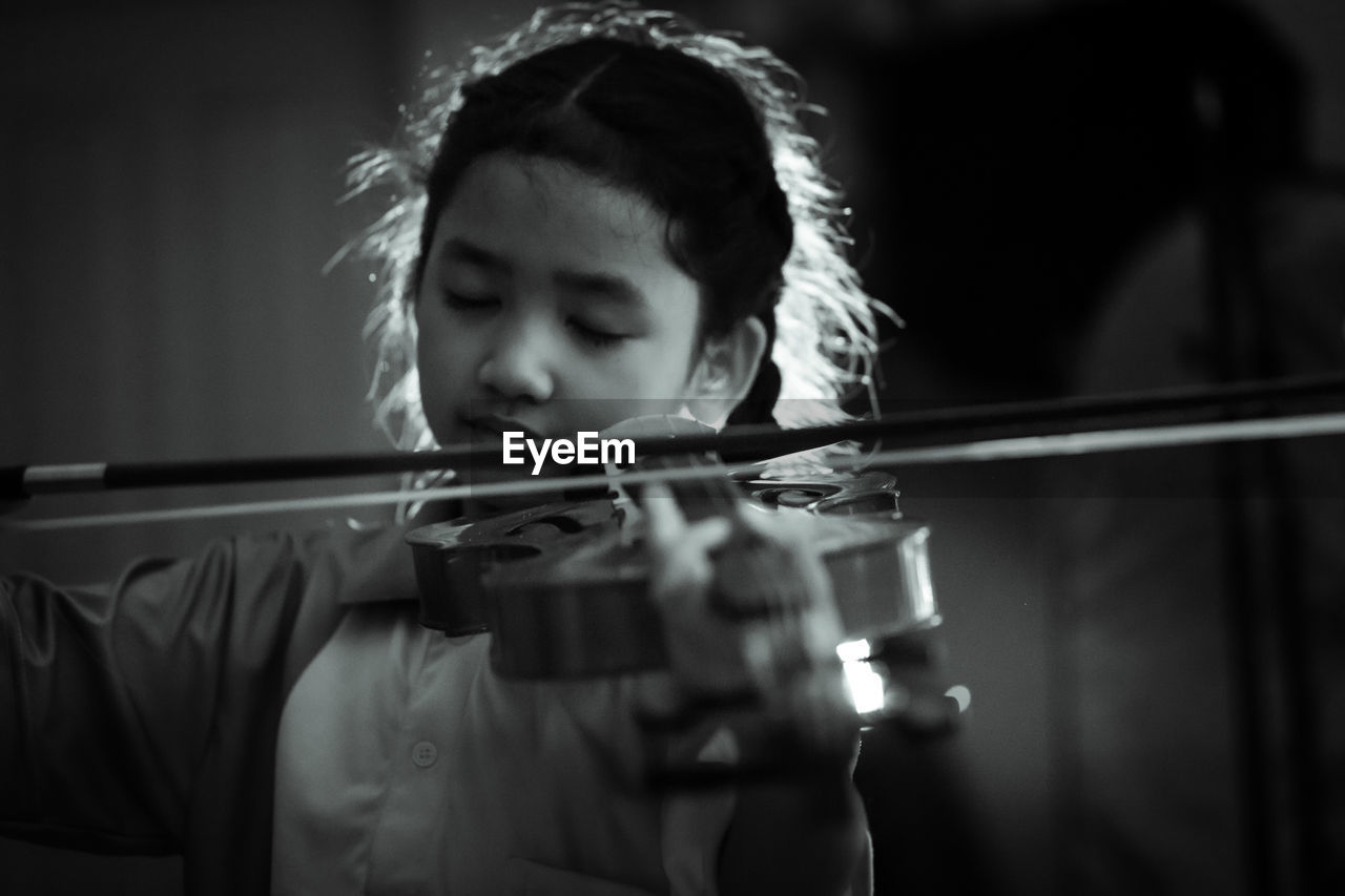 Girl playing musical instrument indoors