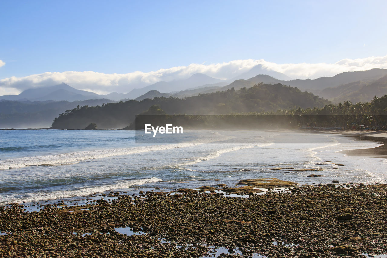 Scenic view of sea and mountains against sky