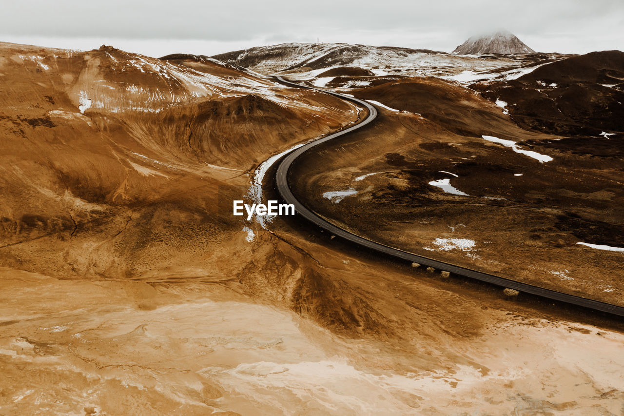 Scenic view of road amidst field during winter