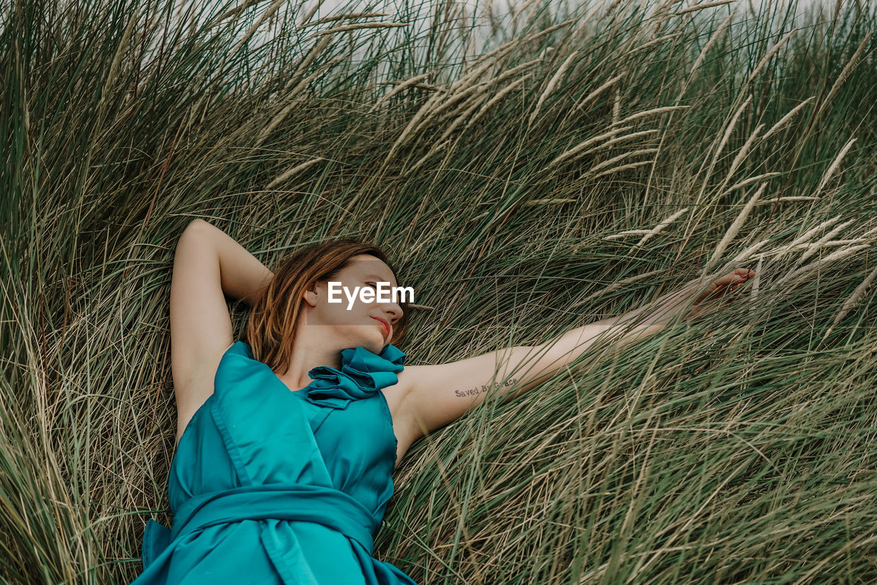 Smiling woman lying on grass