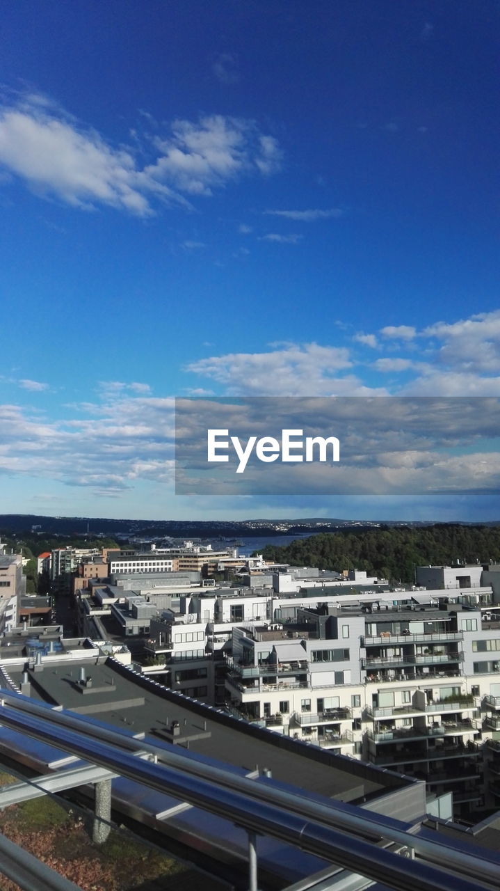 High angle view of cityscape against blue sky