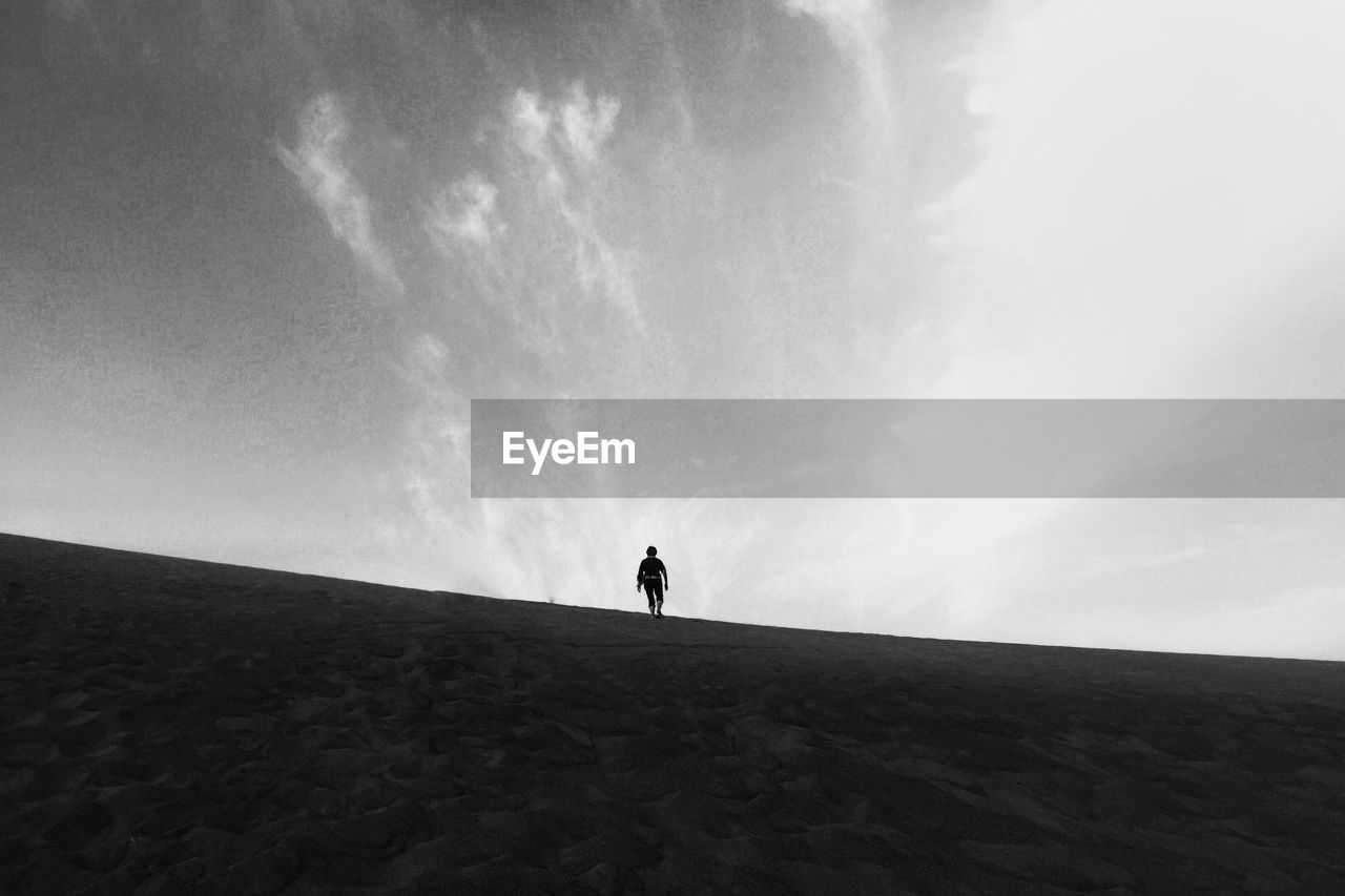 Man standing on field against sky