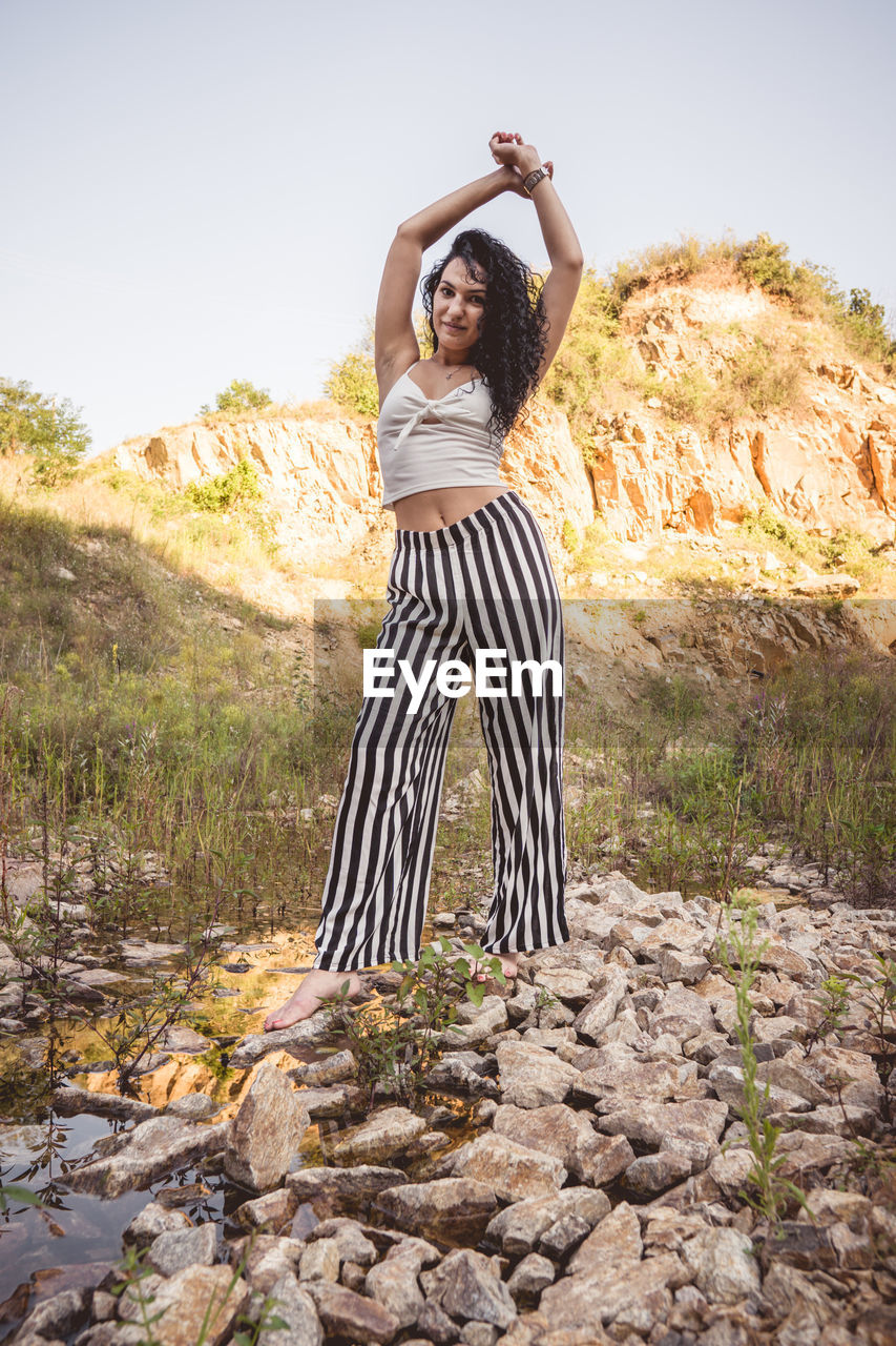 Full length of young woman standing on ground