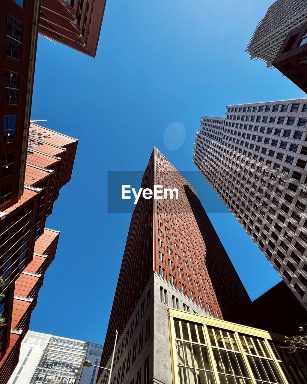 Low angle view of modern buildings against blue sky