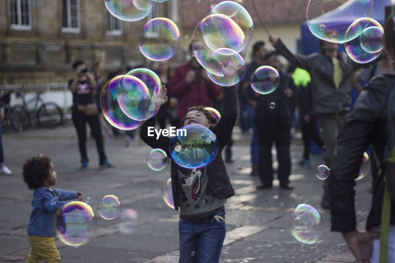 People with bubbles on street in city