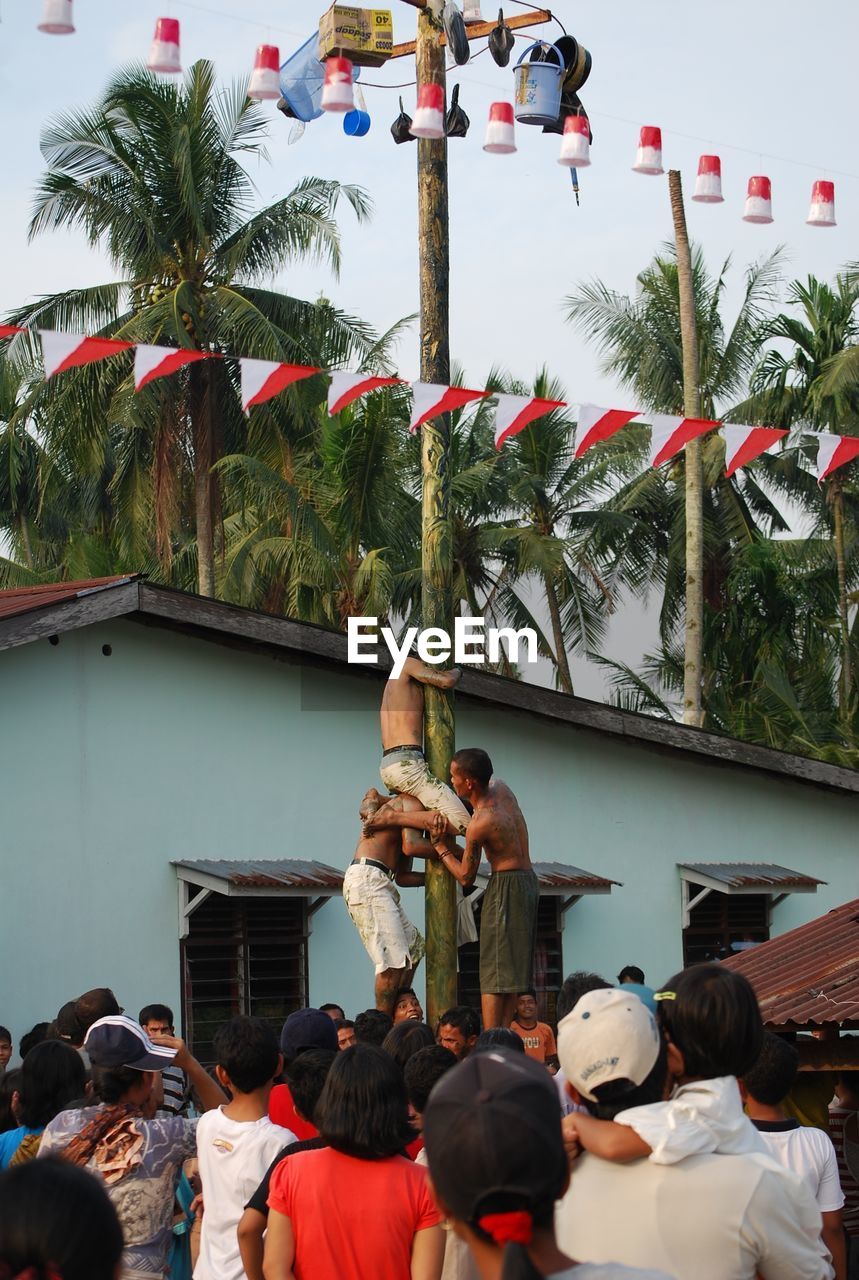 GROUP OF PEOPLE BY THE PALM TREE