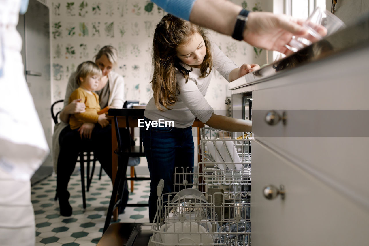 Family of four in kitchen at home