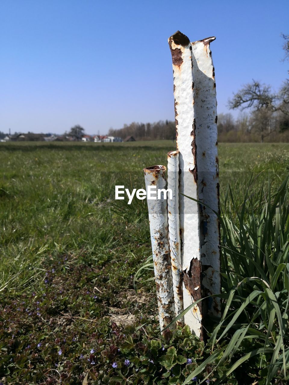 WOODEN POST IN FIELD