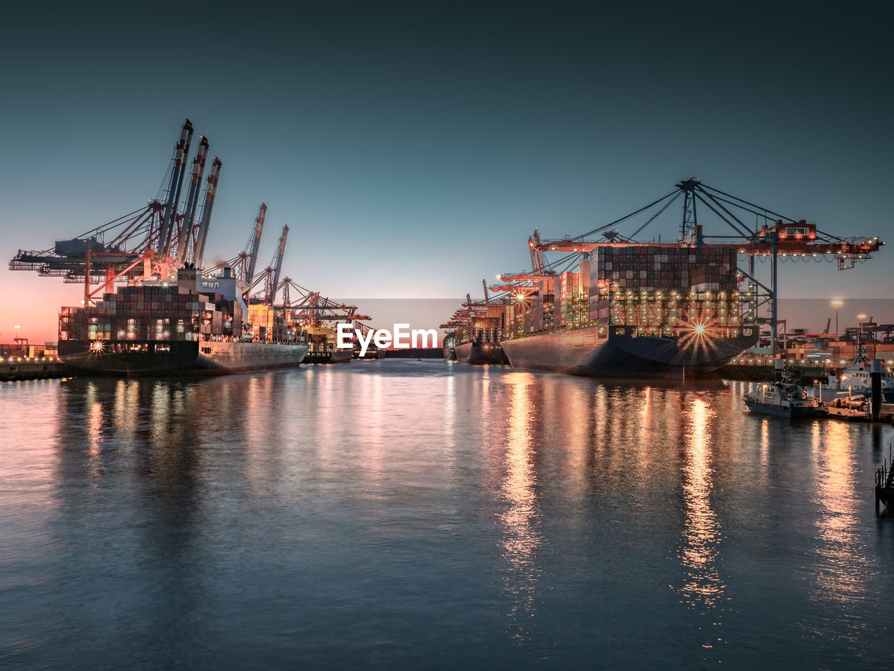 View of illuminated container ship at dock