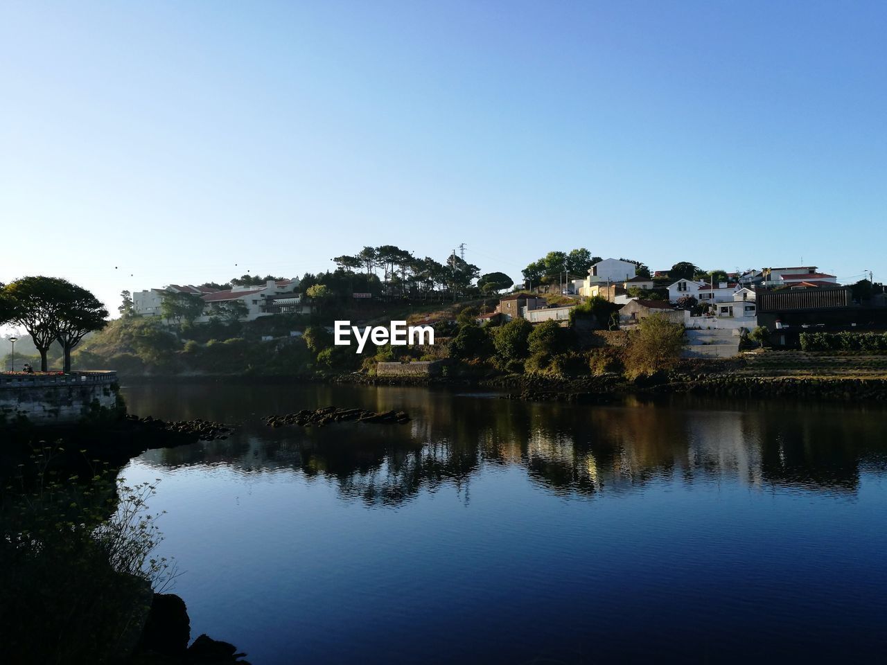 Scenic view of lake by houses against clear sky