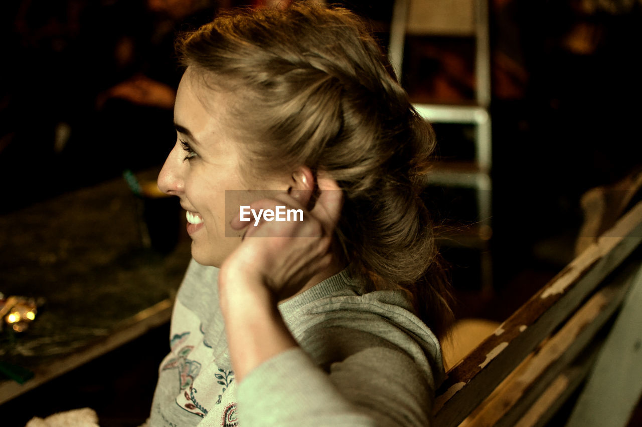 Side view of happy woman sitting on bench