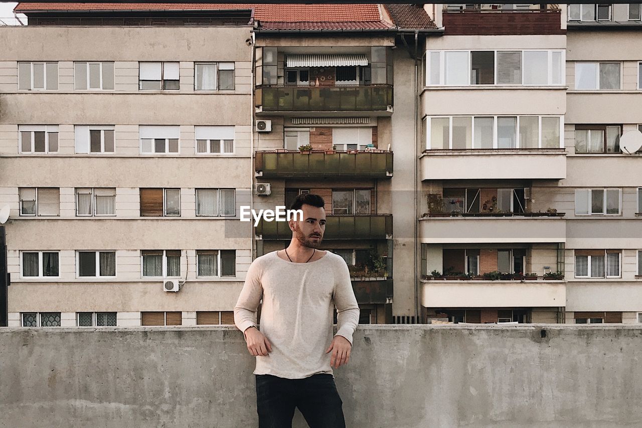 Man standing against building in city