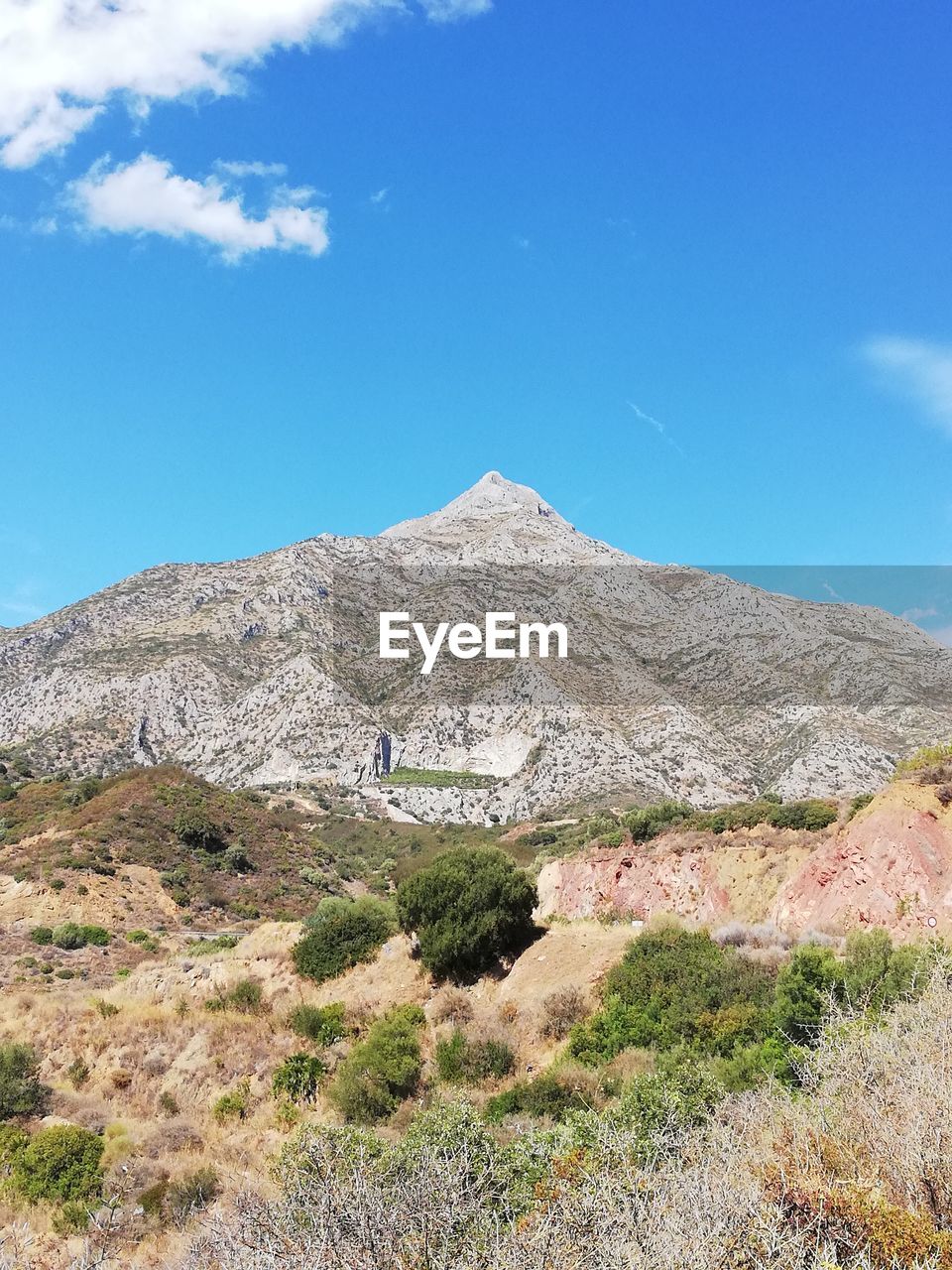 Scenic view of mountains against blue sky