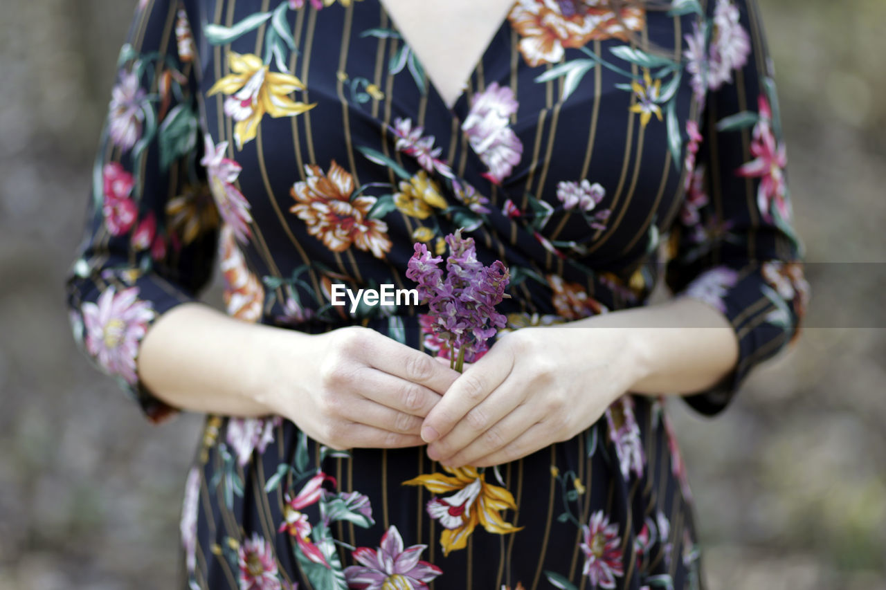 Midsection of woman holding flowers