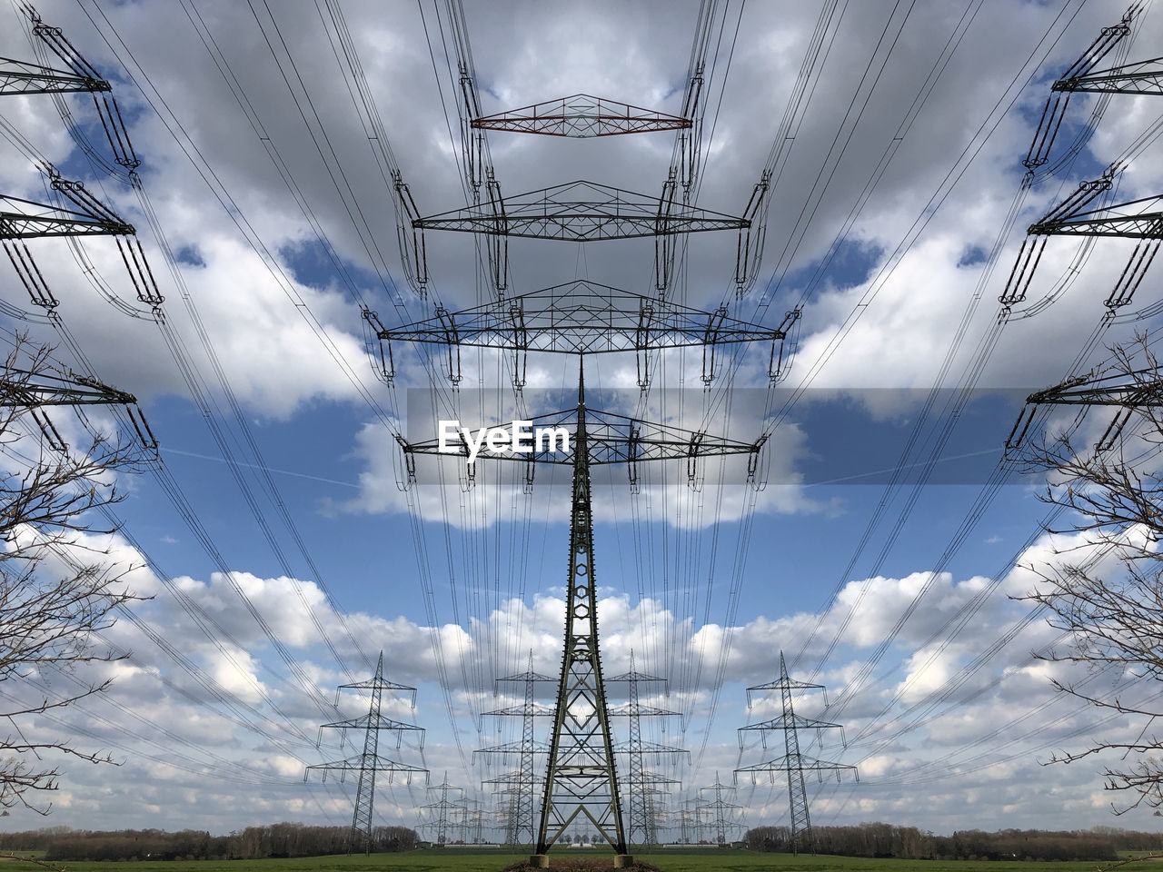 Mirrored low angle view of electricity pylon against sky