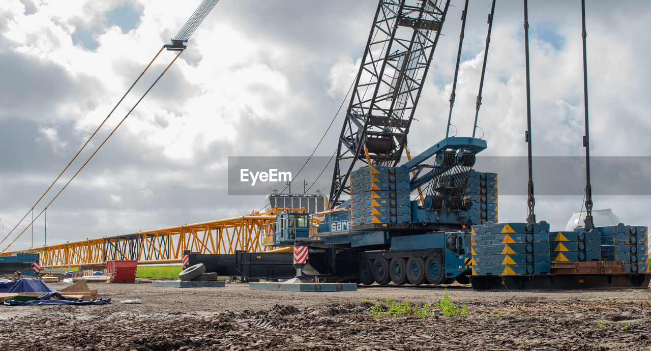 LOW ANGLE VIEW OF CRANES AGAINST SKY