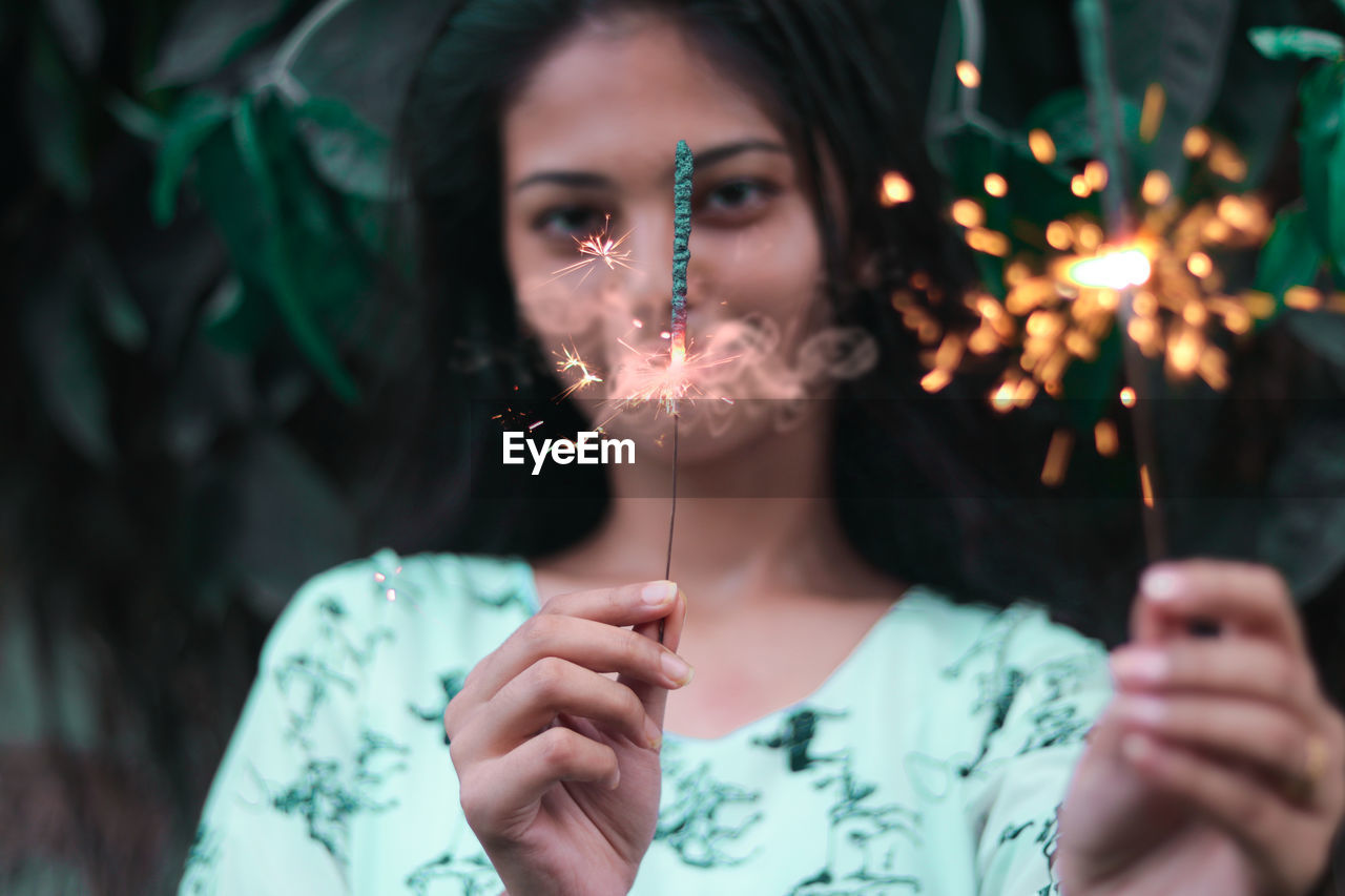 Portrait of teenage girl holding sparklers