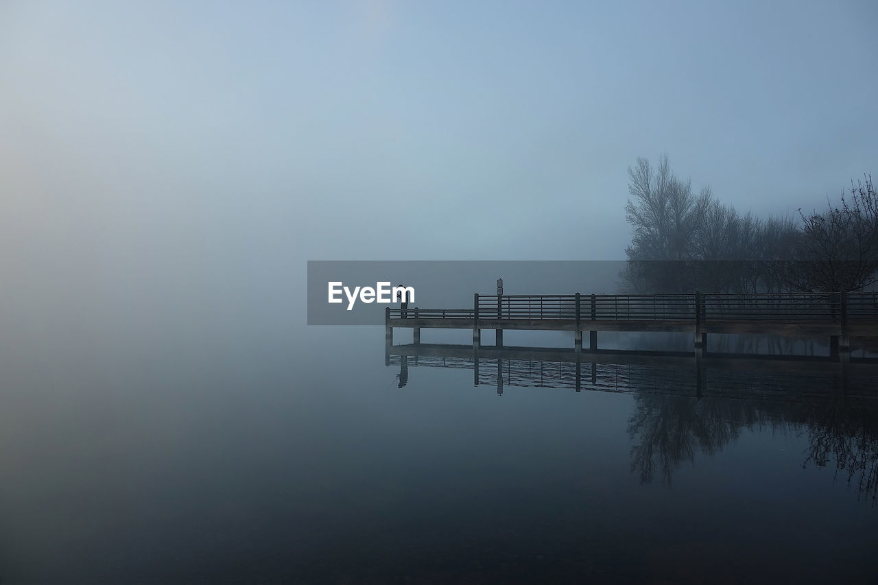 Scenic view of lake against clear sky during sunset