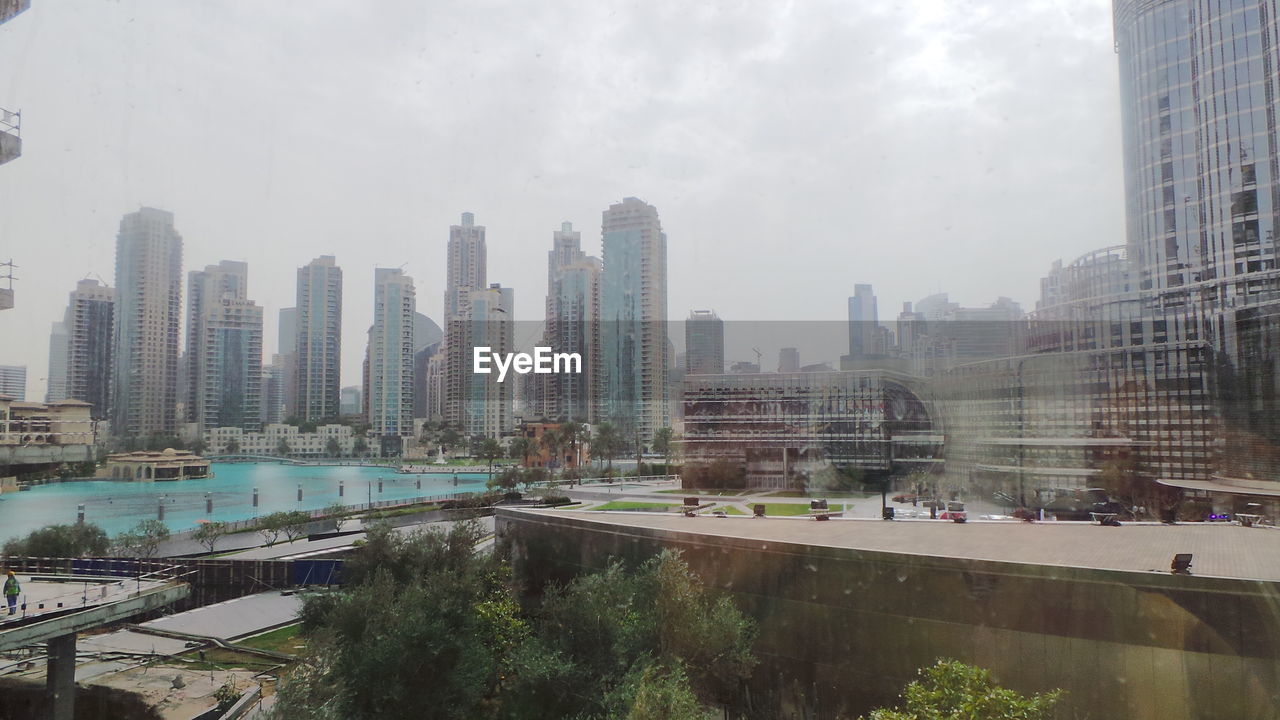 Buildings in city against cloudy sky