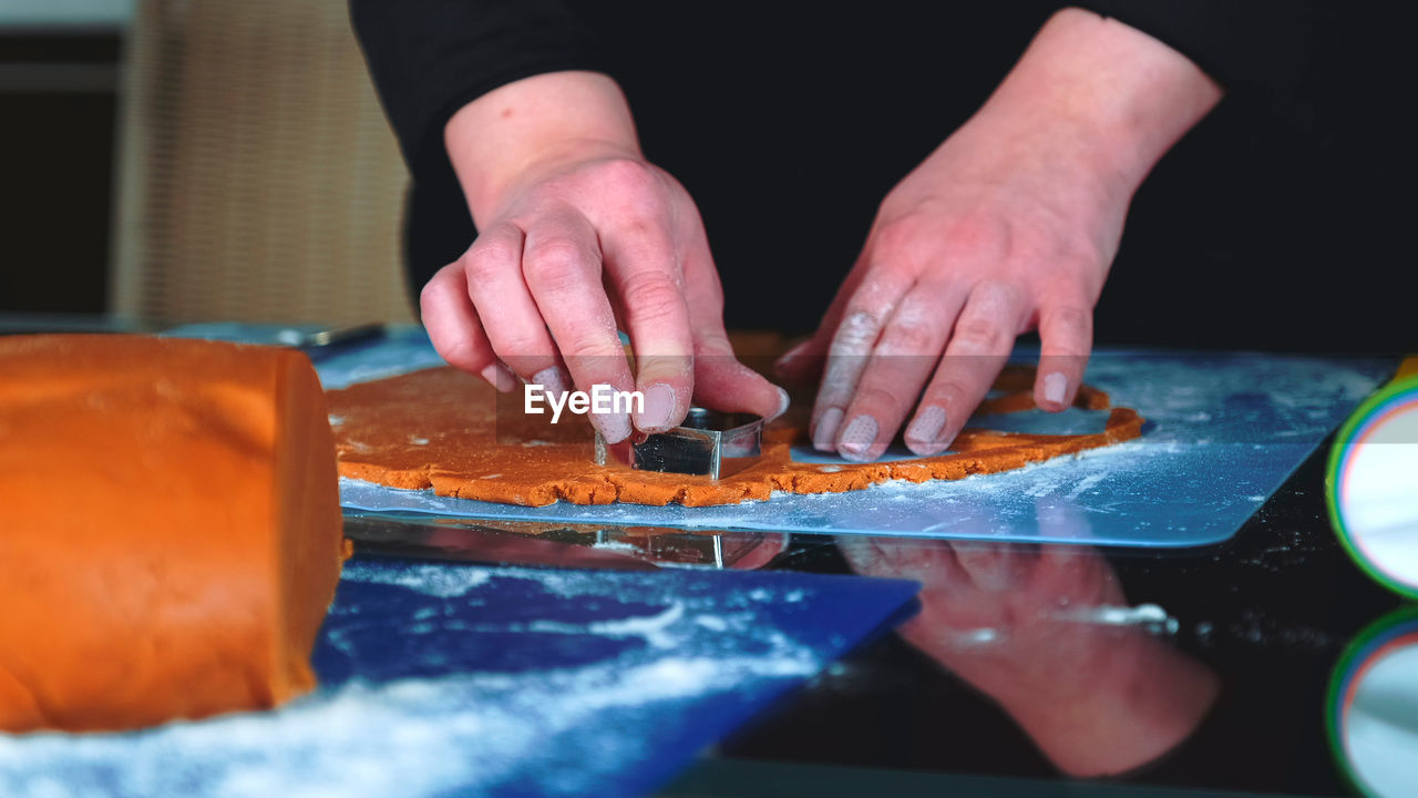 midsection of man preparing gingerbread cookies