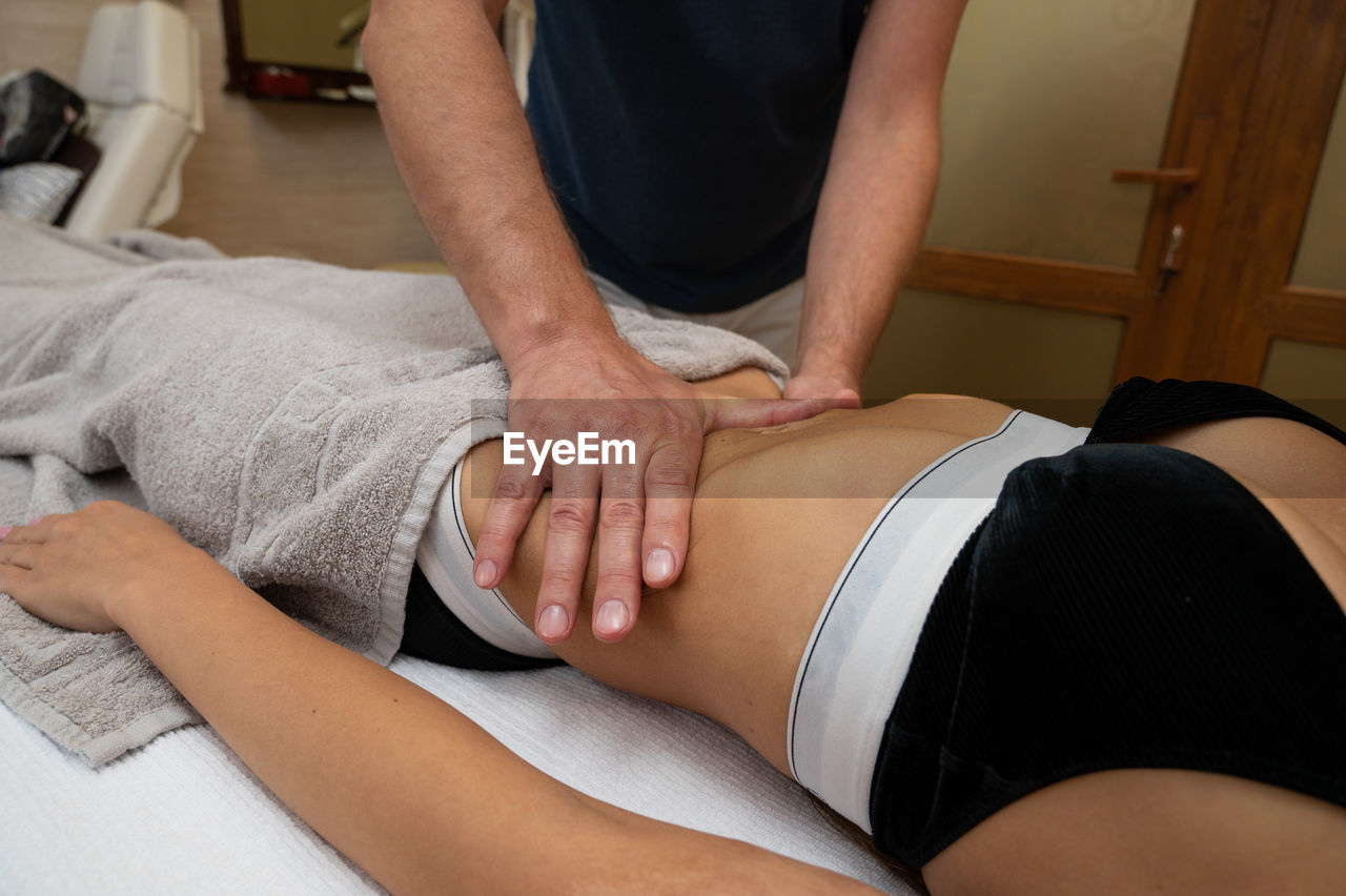 MIDSECTION OF MAN LYING DOWN IN HANDS