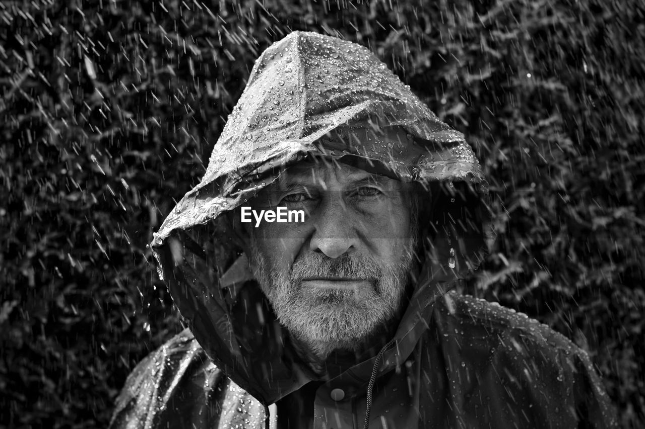 Portrait of man wearing raincoat during rainfall