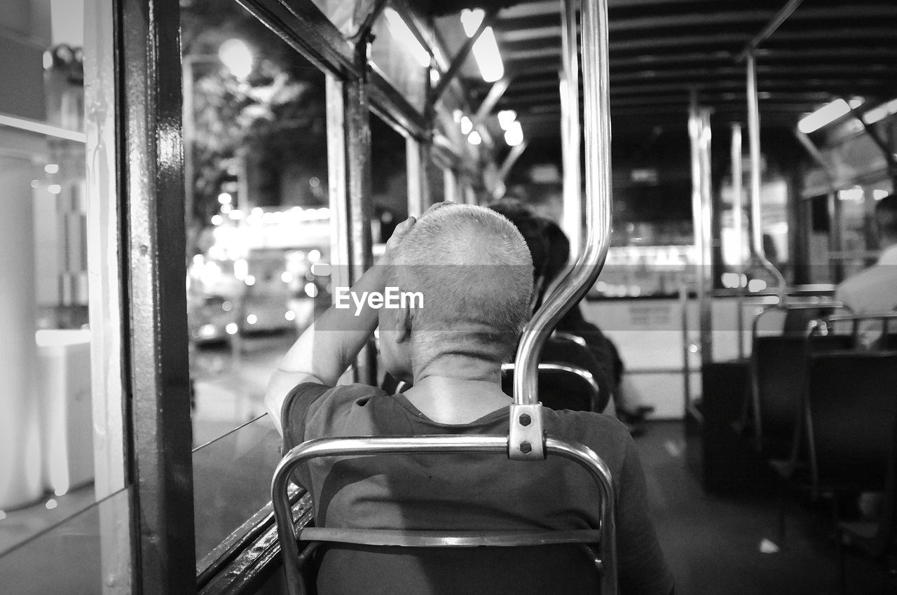 Rear view of mature man sitting in train