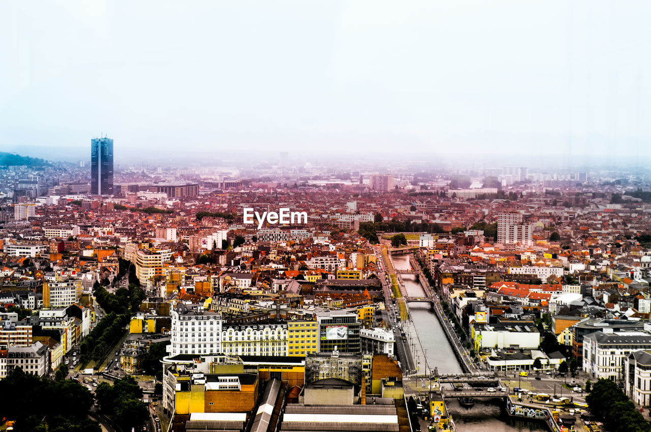 HIGH ANGLE VIEW OF CITYSCAPE AGAINST SKY