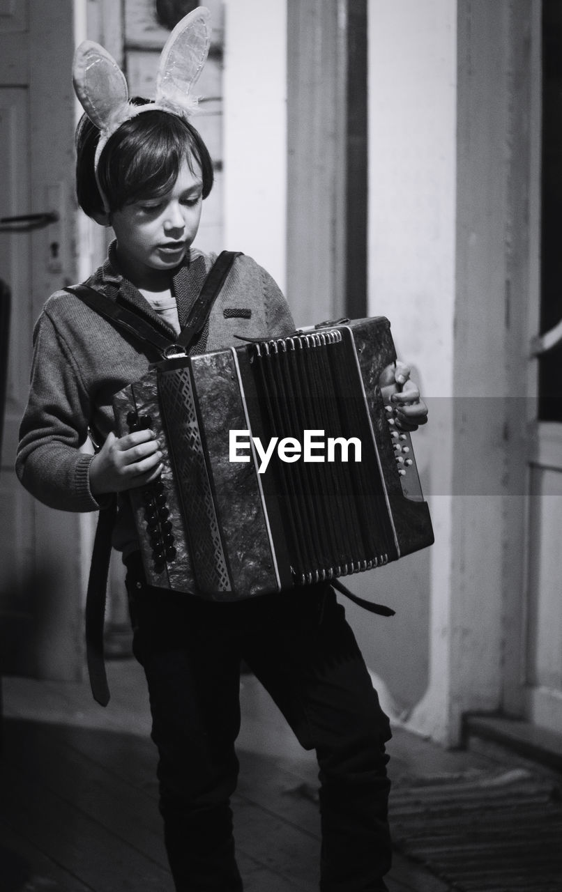 Full length of boy playing accordion